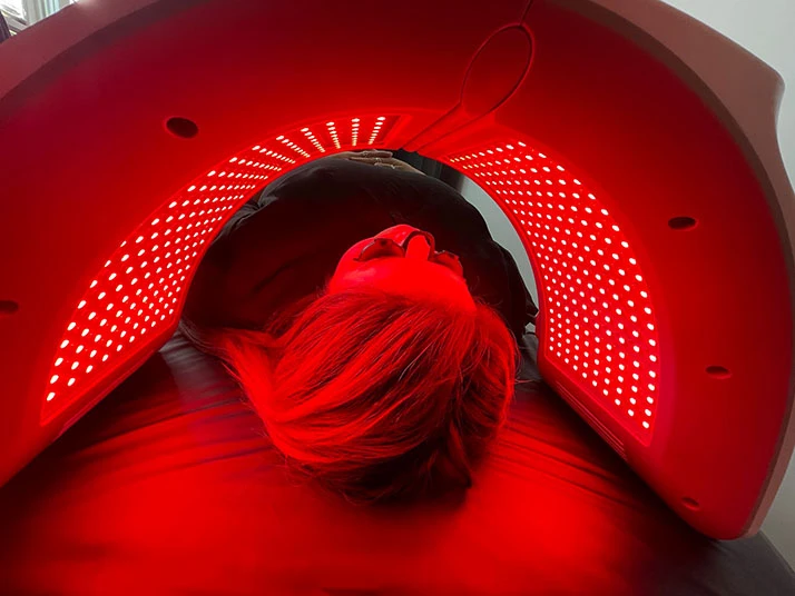 A patient in a red light therapy machine