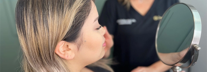 A patient reviewing results of cosmetic acupuncture in the mirror